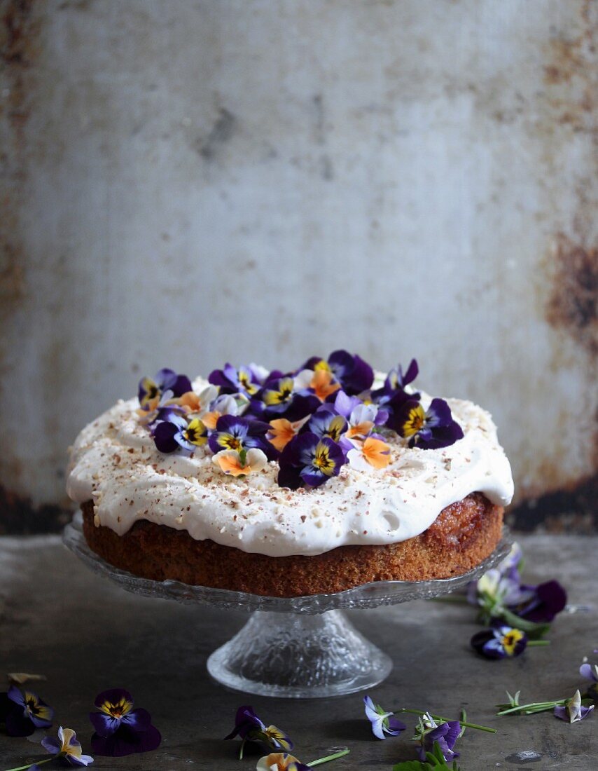 A springtime cake topped with cream and pansies