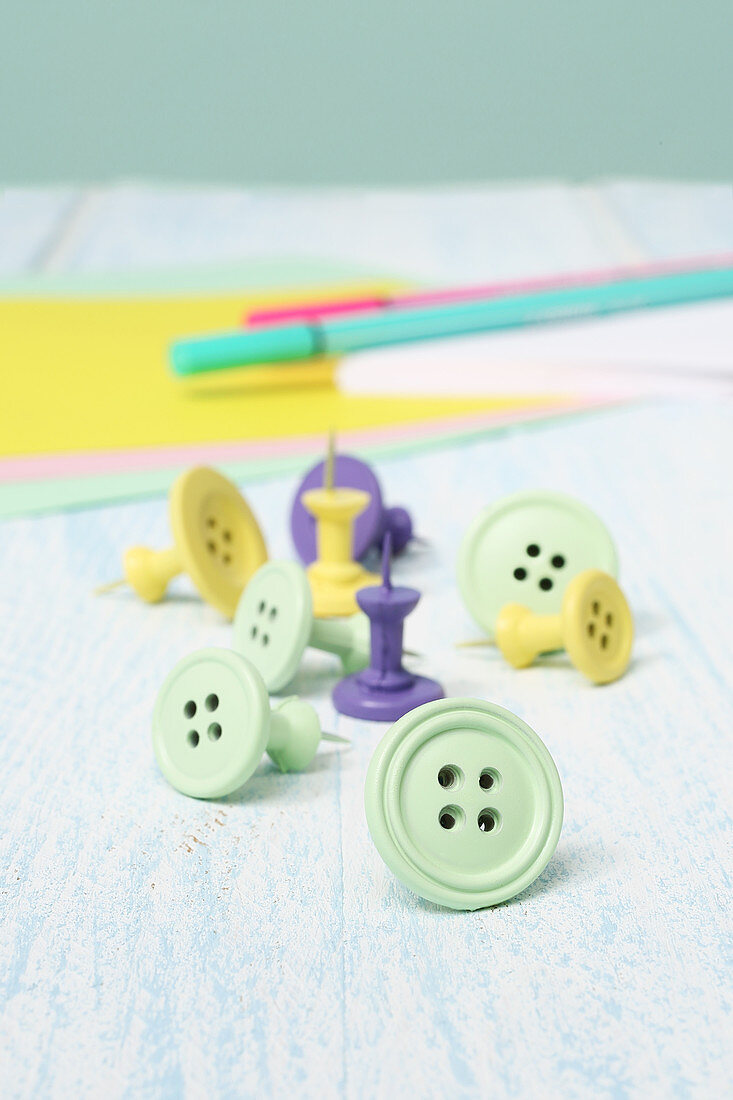 Buttons stuck on drawing pins painted pastel colours