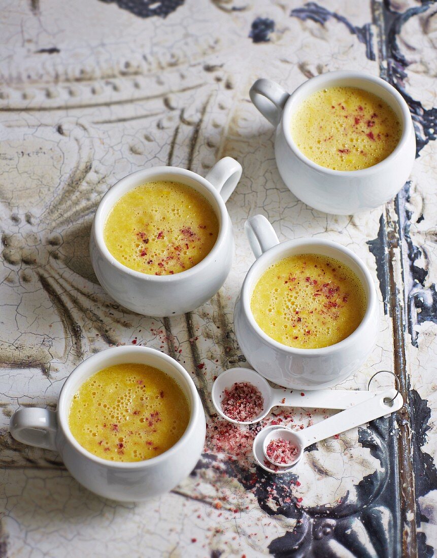 Yellow pepper soup with pink flower salt