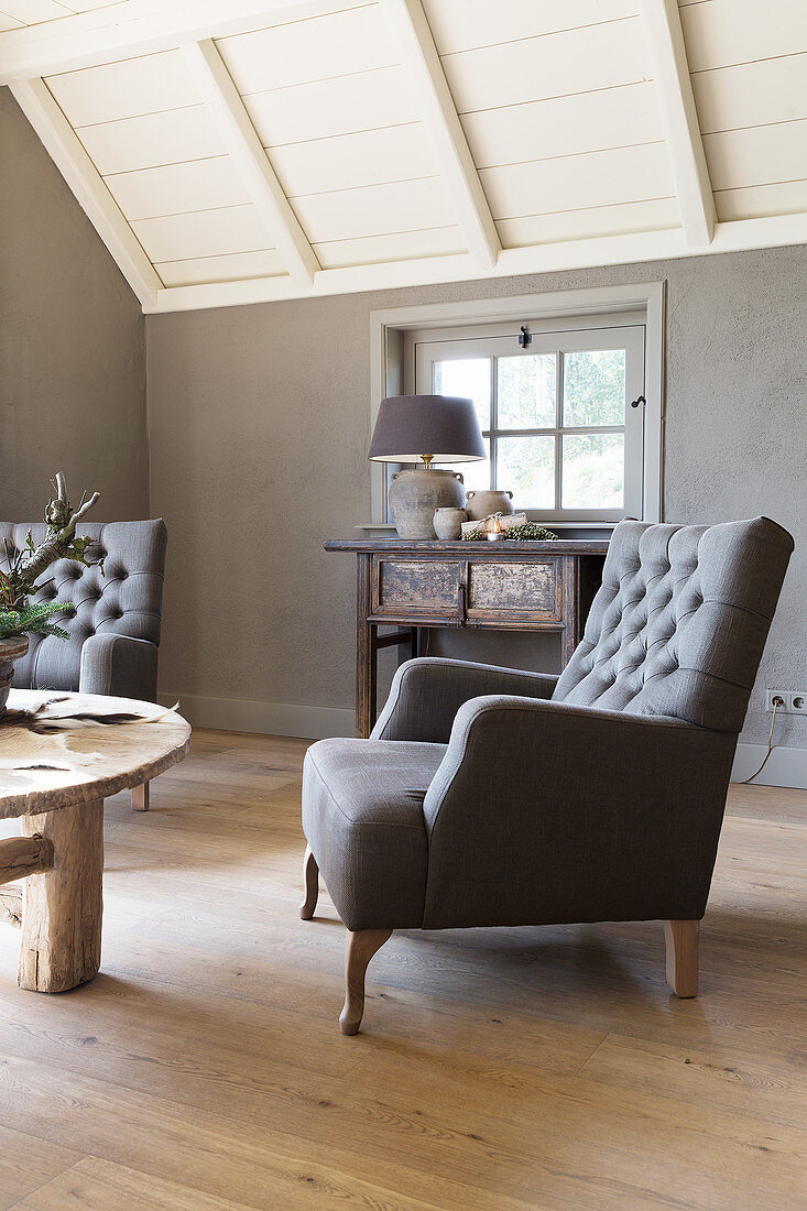 Classic armchair in living room with grey wall and wooden floor
