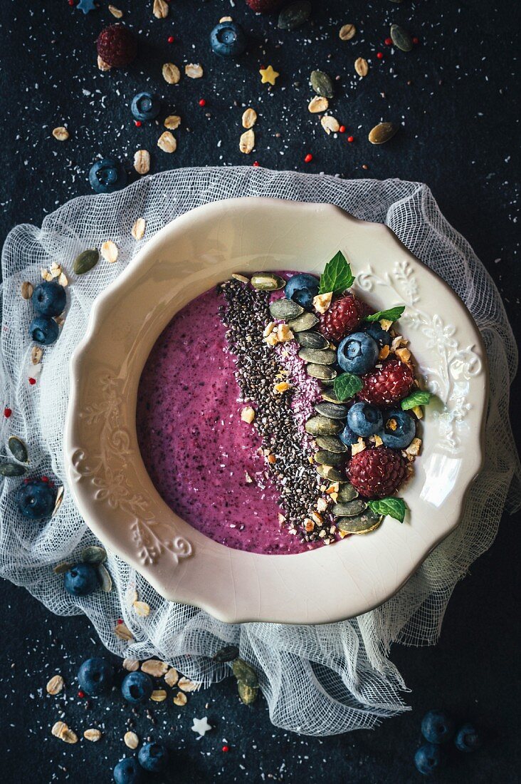 Berry smoothie bowl with chia, pumpkin seeds and oat flakes