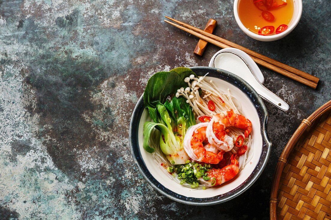 Rice noodles with Shrimps, Bok choy cabbage and Enoki mushrooms on metal background