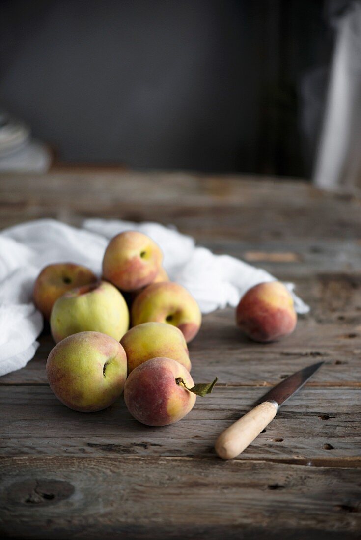 Stillleben mit frischen Pfirsichen auf rustikalem Holztisch