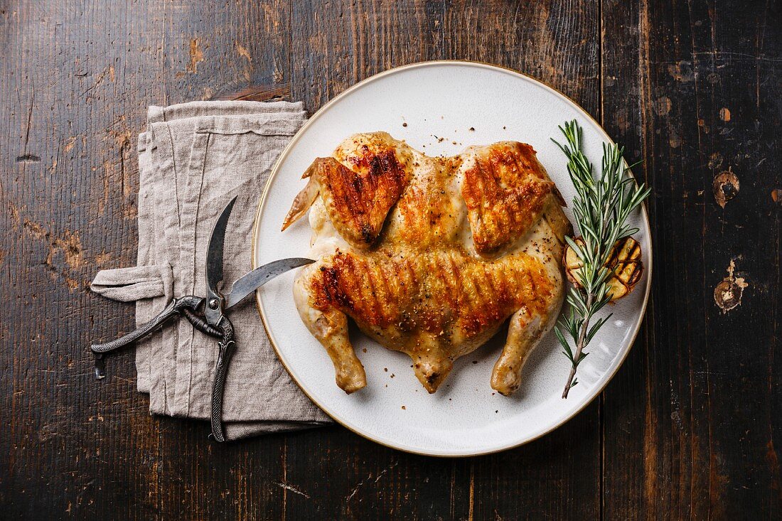 Grilled fried roast Chicken Tabaka on plate on wooden background