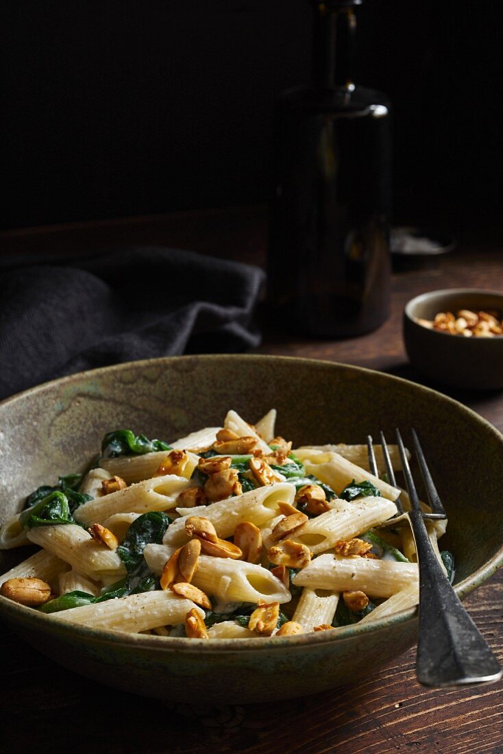 Penne with spinach and caramelised peanuts in goat's cheese sauce