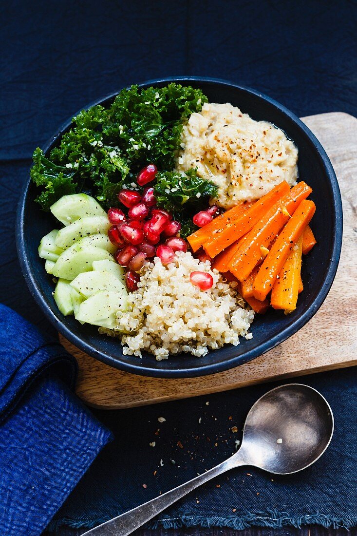 Buddha bowl with quinoa, hummus, green cabbage and pomegranate seeds