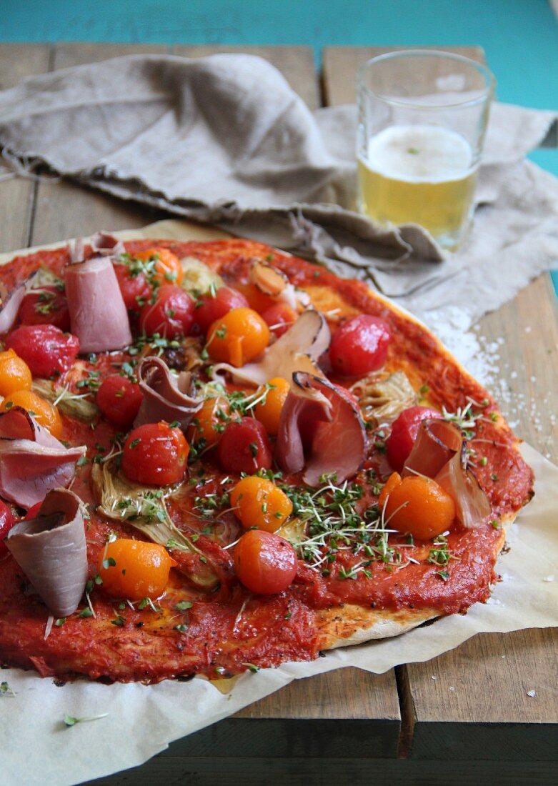 Pizza with ham, cherry tomatoes and thyme