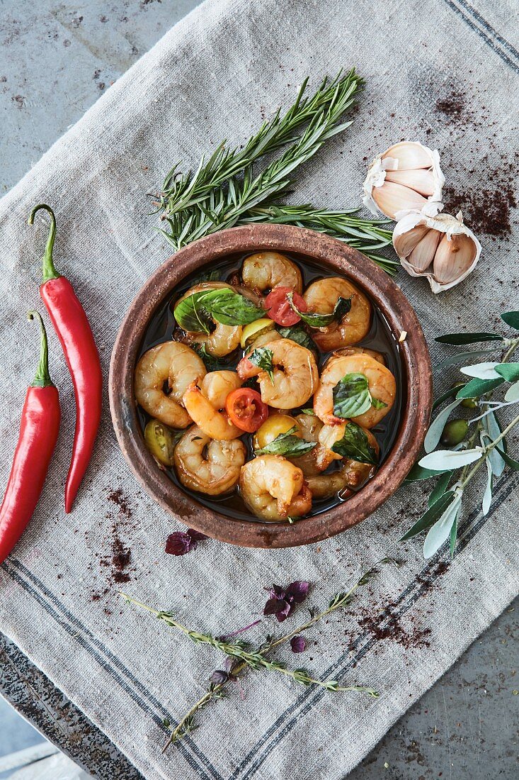 Garlic prawns with tomatoes and fresh herbs in a rustic serving dish