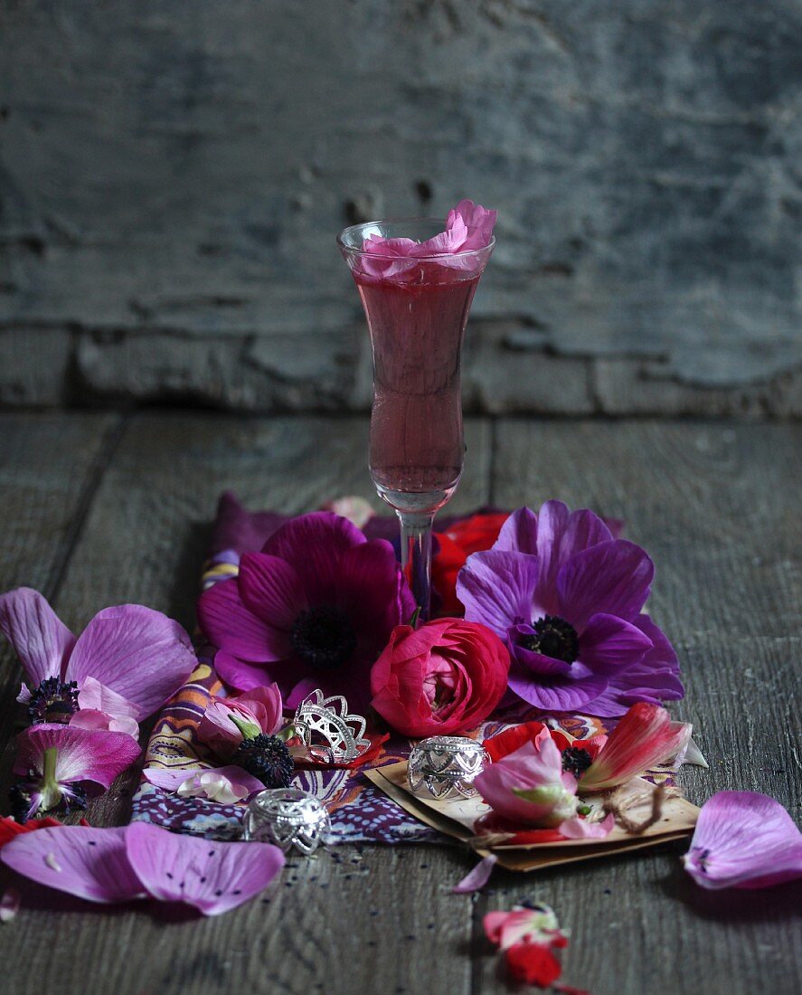 Pinkfarbener Cocktail inmitten von Blüten