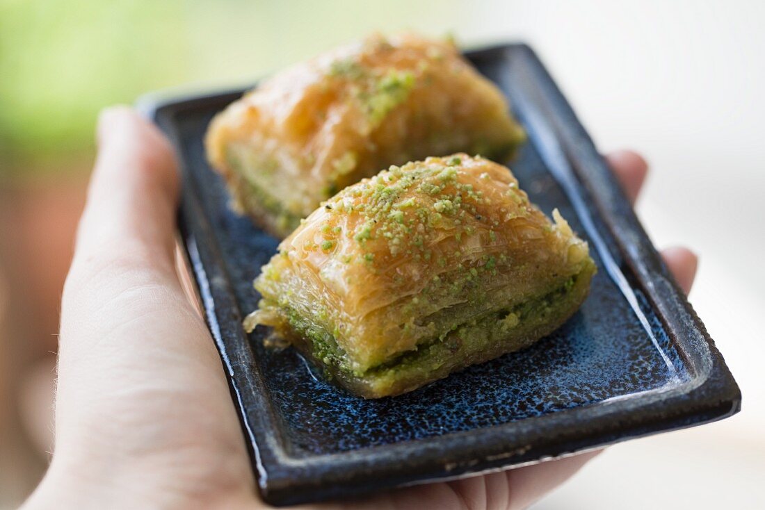 Hand hält Baklava mit Pistazien