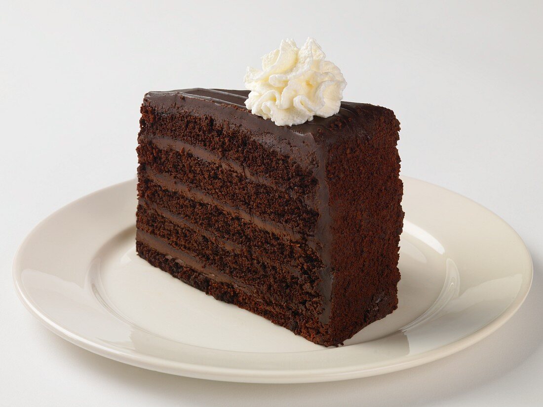 A Slice of Rich Chocolate Layer Cake with Whipped Cream