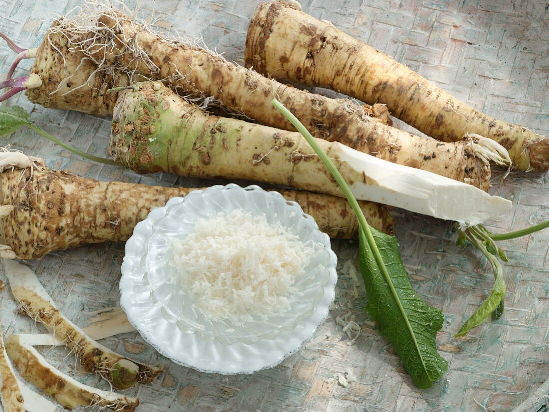 Horseradish roots and peel with grated horseradish and horseradish leaves