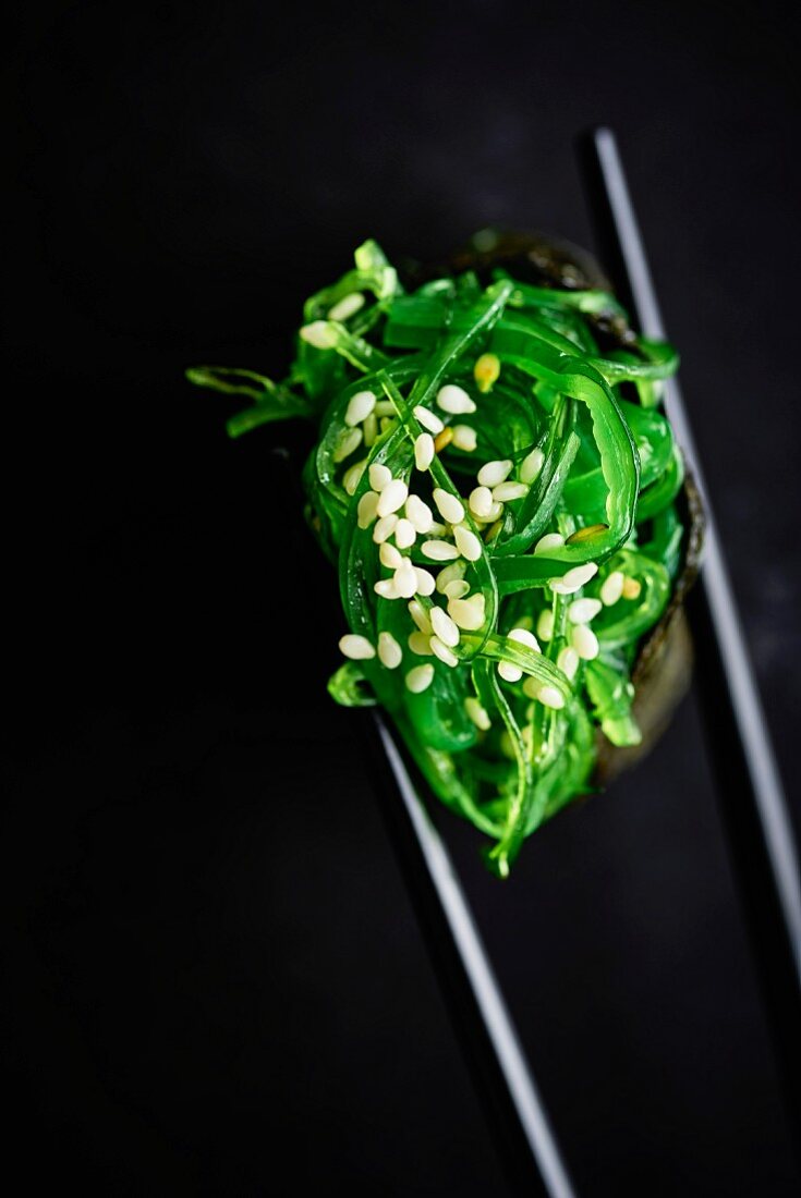 Gunkan-Sushi mit Algen auf Essstäbchen