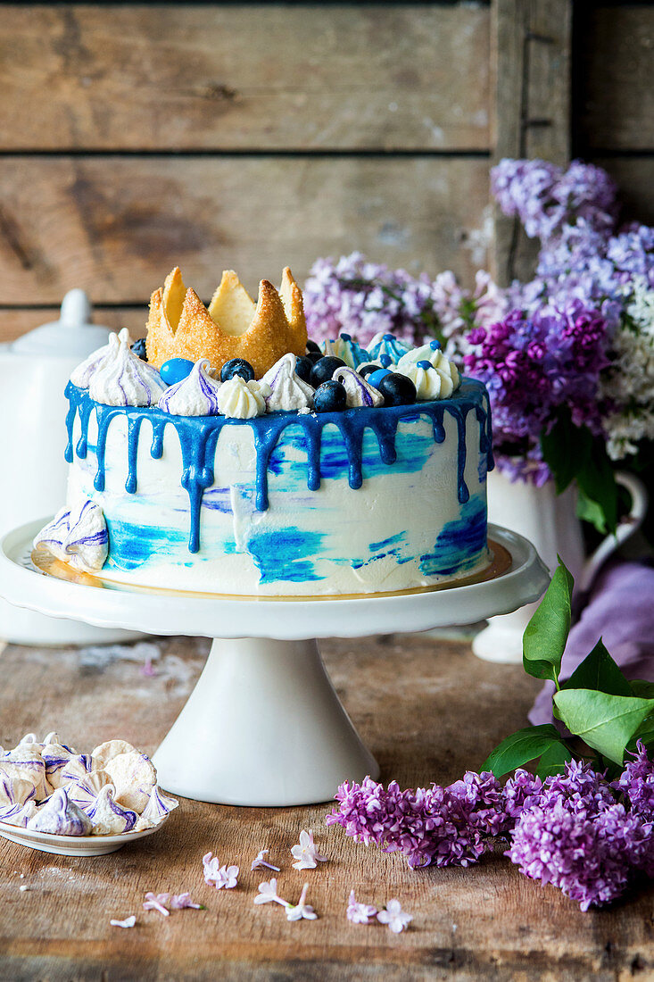 A birthday cake with blue-and-white decorations and a crown