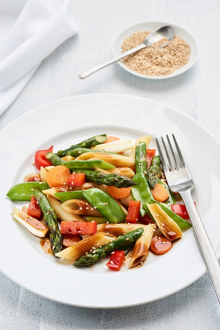 Nudelsalat auf asiatische Art mit grünem Spargel, Zuckerschoten, Frühlingszwiebeln, roter Paprika und Karotten