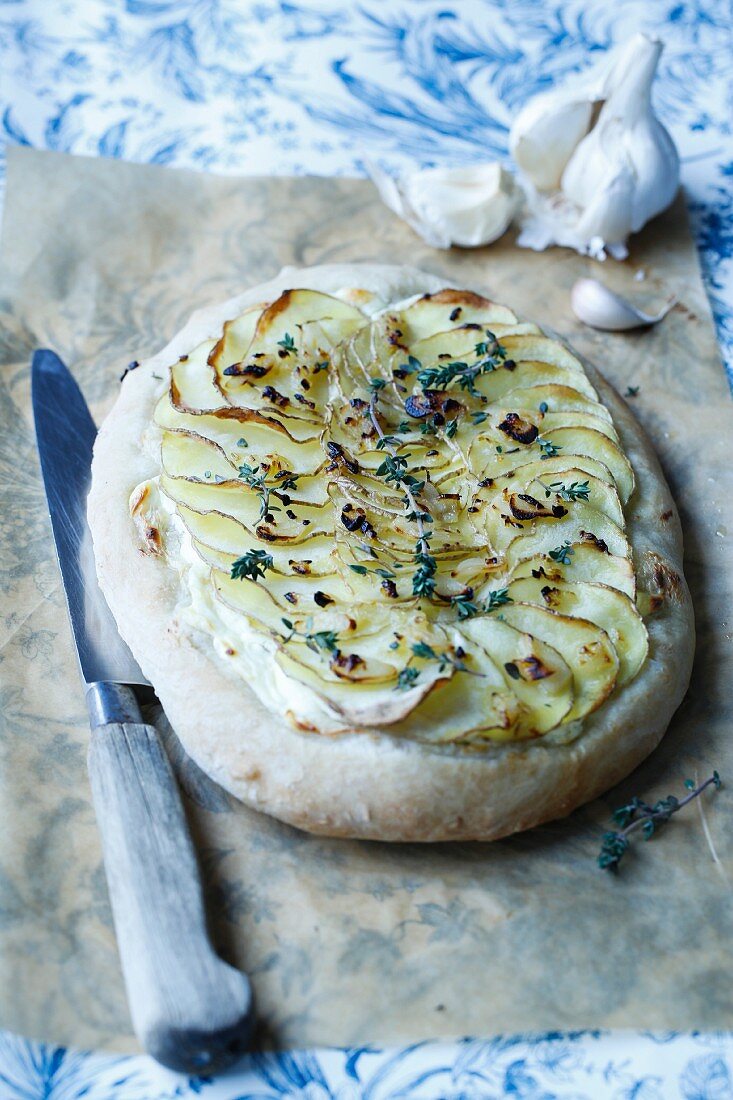 Pizza mit Frischkäse, Knoblauch, gehobelten Kartoffeln und Thymian