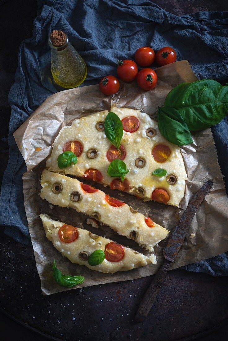 Vegan focaccia with tomato, olives and basil