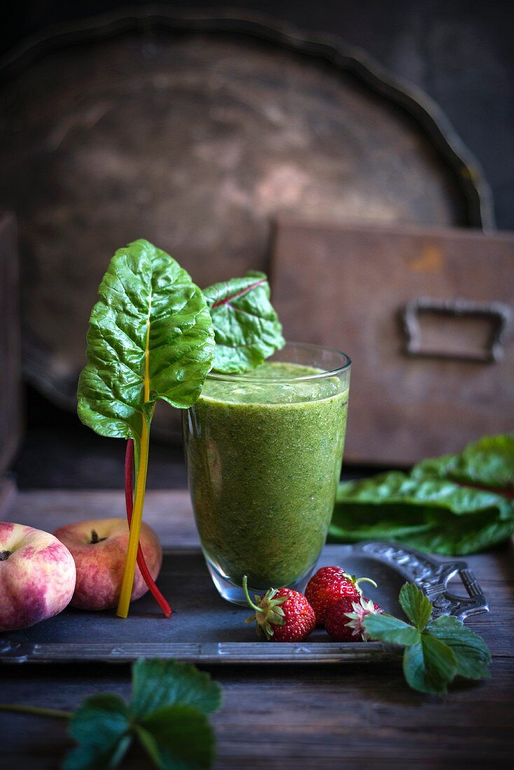 A green smoothie made of chard, strawberries and peaches