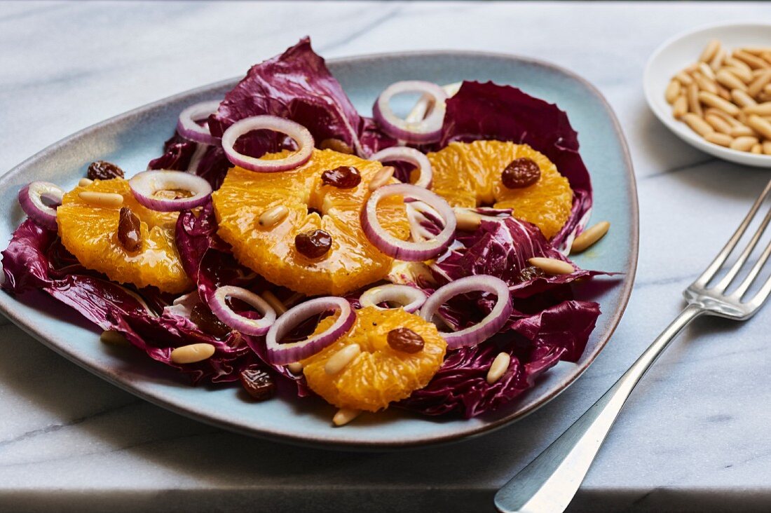 Winterlicher Radicchiosalat mit Orangen, roten Zwiebeln, Rosinen und Pinienkernen