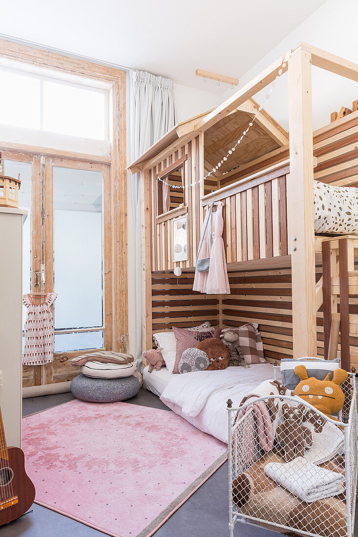 Pink rug and striped wooden bunk beds in children's bedroom