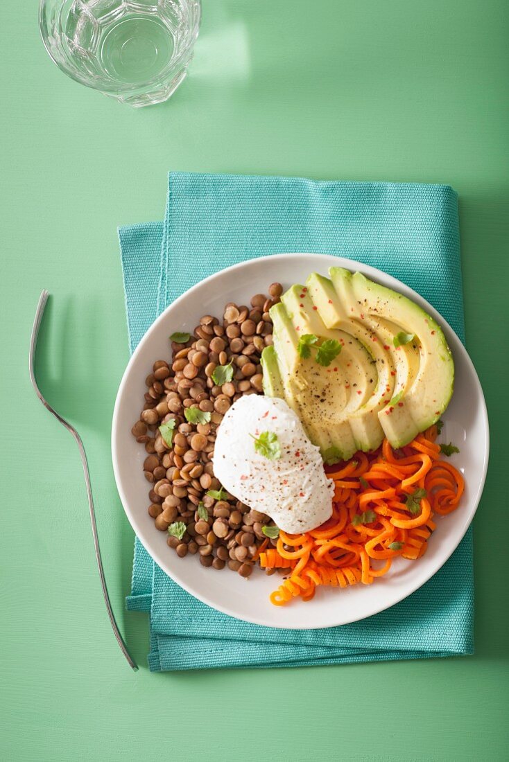 Spiralized carrot and avocado bowl with poached egg and lentil