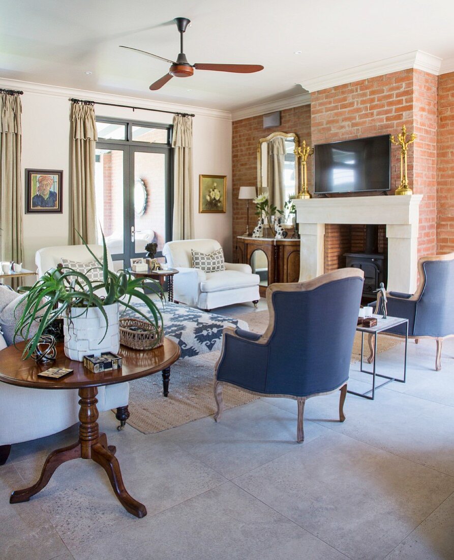 Various armchairs and fireplace in brick wall in living room