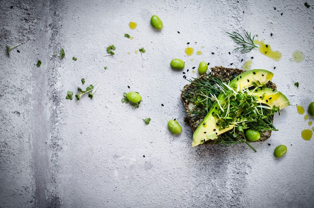 Vollkornbrotscheibe mit Avocado, Edamame und Kresse