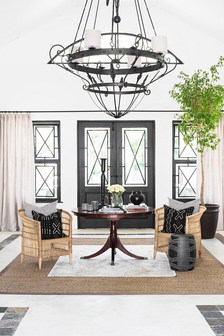 Chandelier and wicker armchairs in elegant foyer