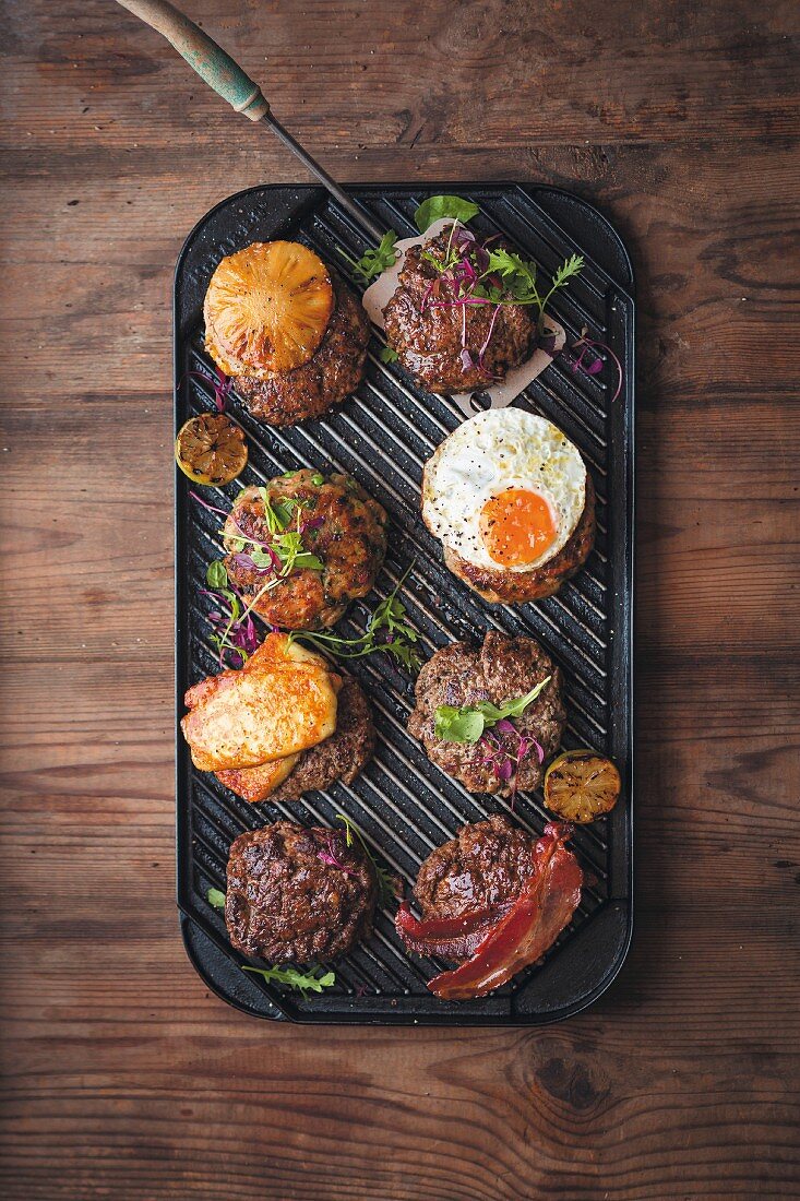 Various burgers on a grill pan