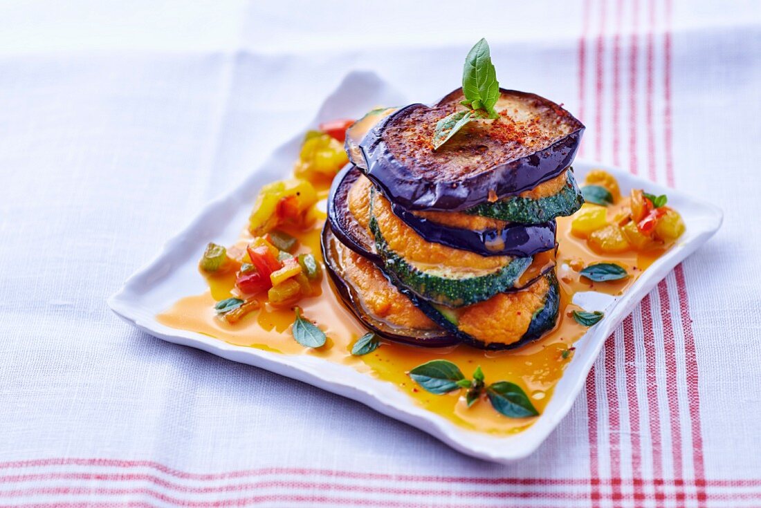 A ratatouille tower with pepper sauce