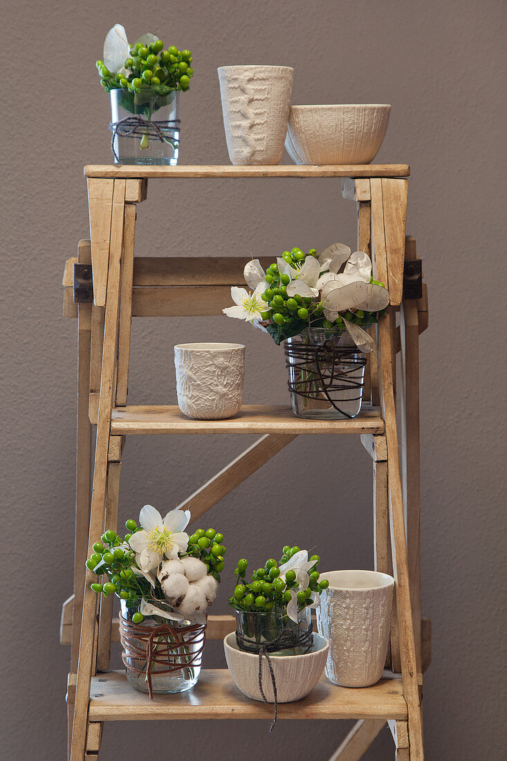 Posies in vases with knitted structures on ladder