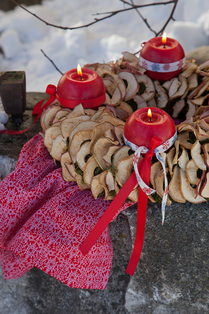 Adventskranz mit Kugelkerzen und getrockneten Apfelringen