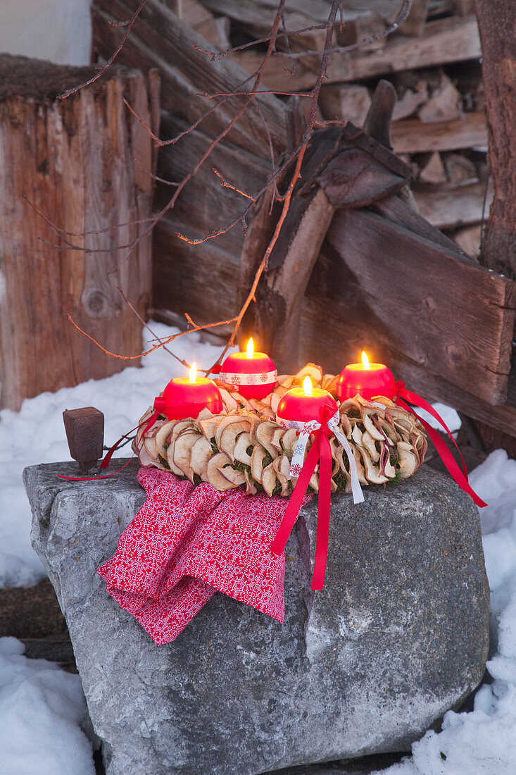 Adventskranz mit Kugelkerzen und getrockneten Apfelringen