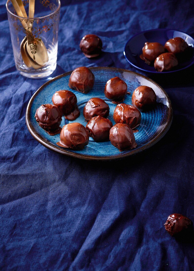 Round chocolate truffles on a blue plate