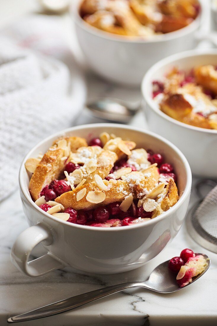 Mini-Ofenschlupfer (Brotauflauf) in der Tasse mit Johannisbeeren und Vanillesauce