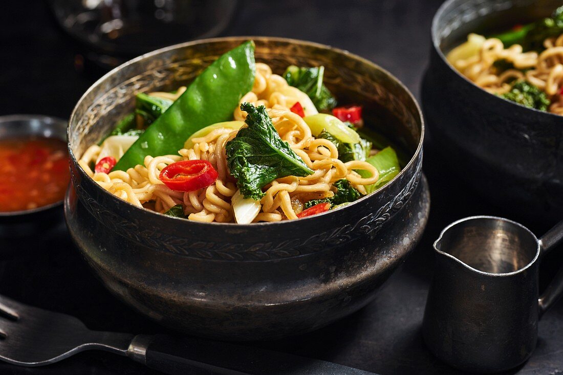 Asian noodles with kale, sugar snap peas, spring onions, and chili peppers