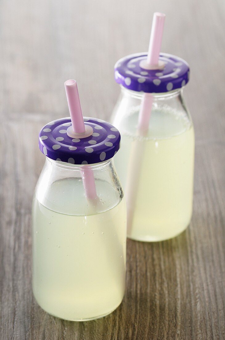 Lemonade in two bottles with straw