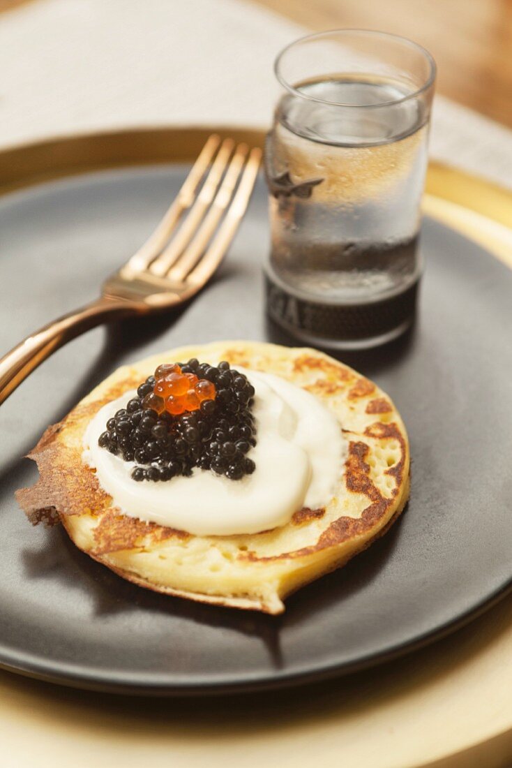 A blini with crème fraiche and caviar