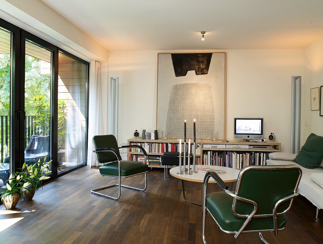 Exotic-wood parquet floor, modern artwork and glass wall leading to balcony in retro living room