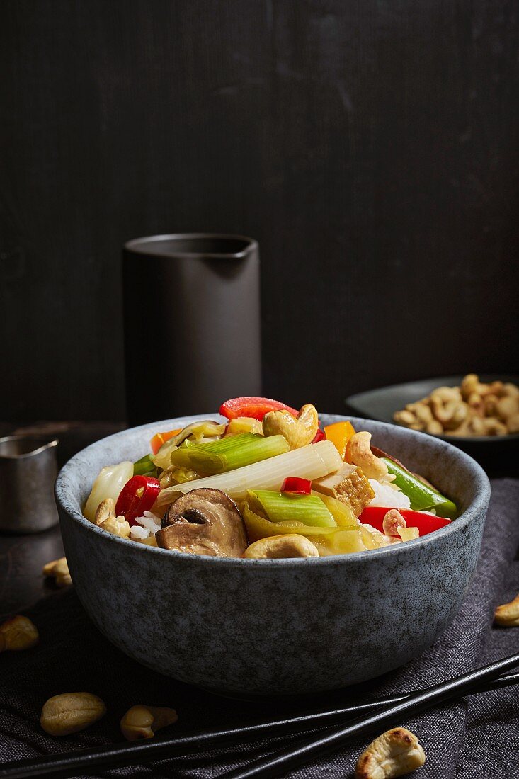 Wok vegetables with smoked tofu, mushrooms, and cashew nuts on rice (Asia)