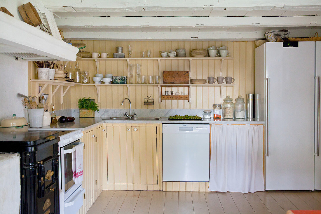 Landhausküche mit Regalen und gelber Wandverkleidung