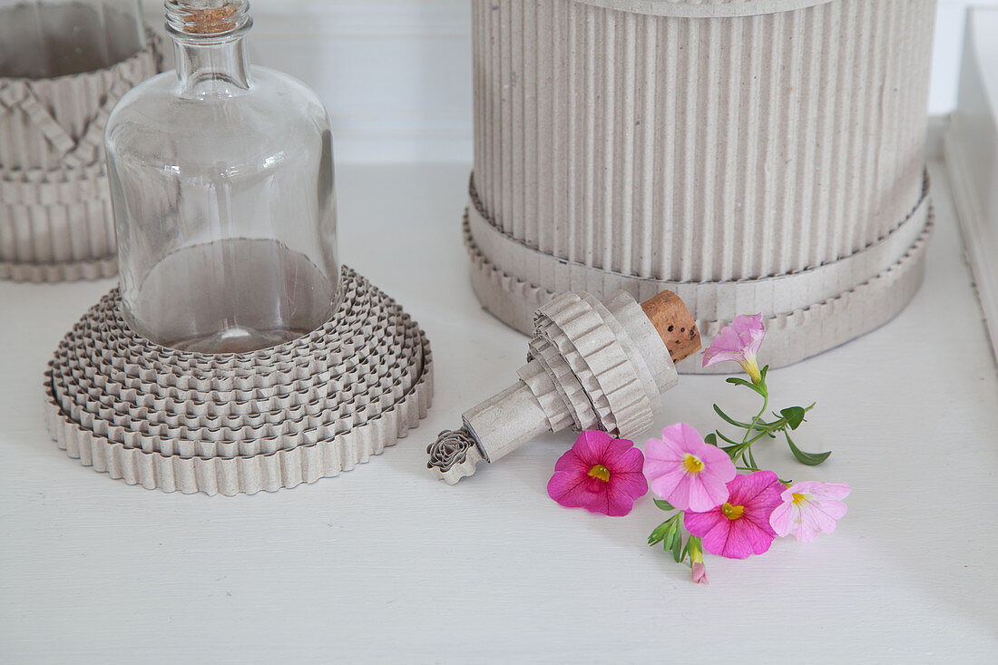 Petunias next to cork and bottles with collars made from corrugated cardboard