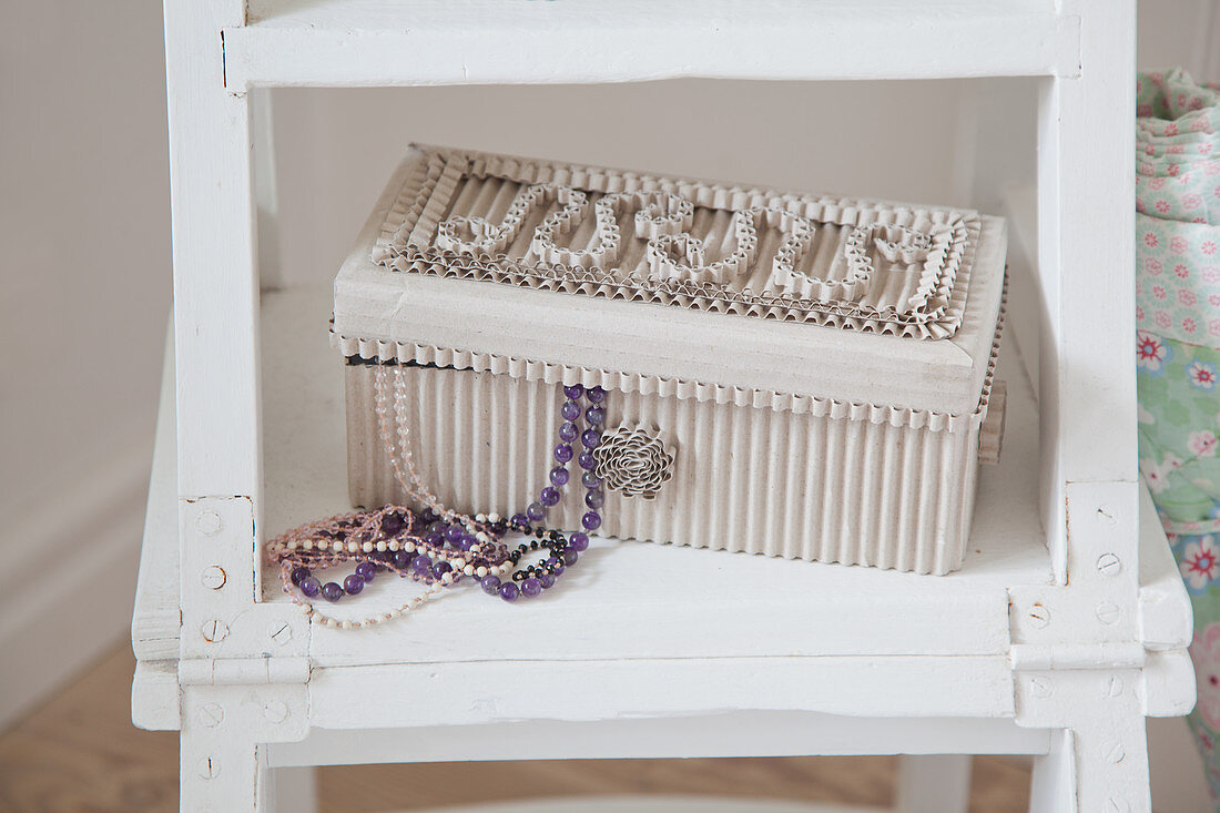 Jewellery box made from corrugated cardboard and bead necklace on ladder