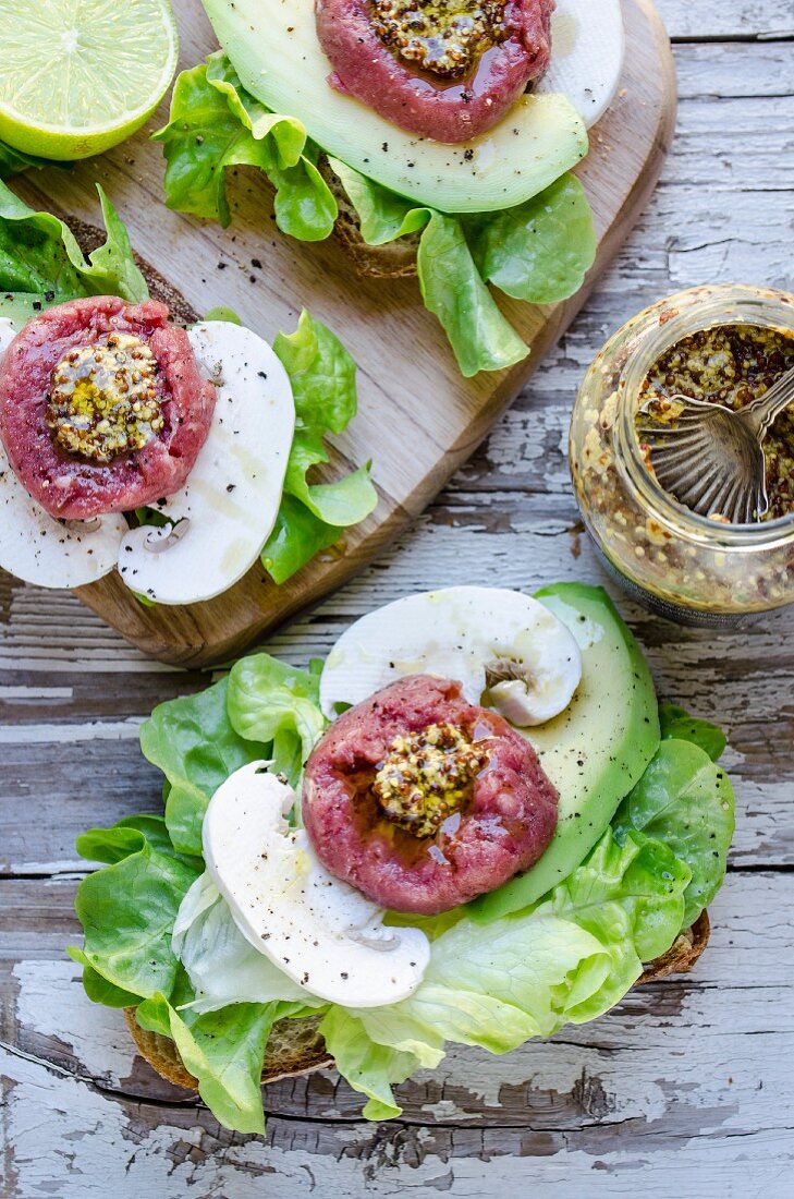 Open sandwiches with beef tartar, mustard, mushrooms, avocado and lettuce