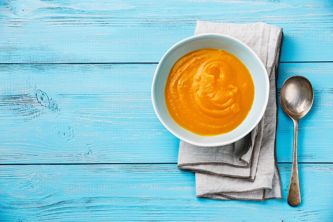 Pumpkin soup on blue wooden background