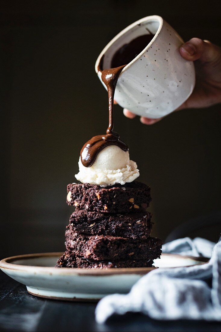 A brownie sundae drizzled with chocolate sauce