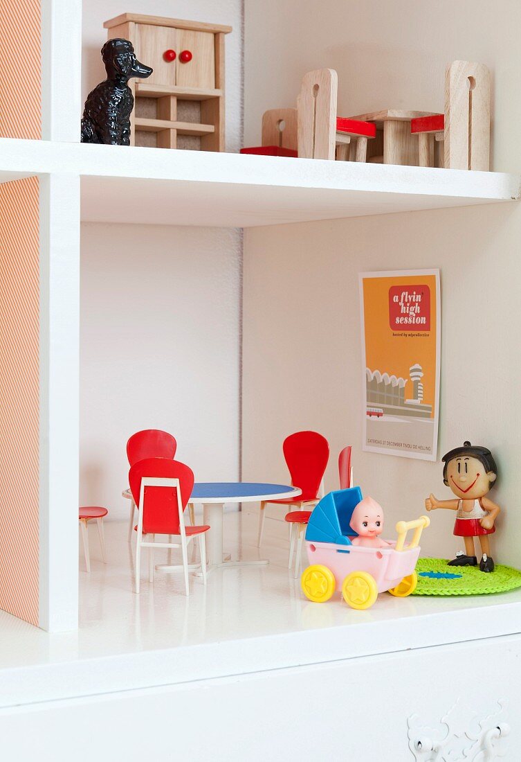 Retro dolls' furniture in white cabinet converted into dolls' house