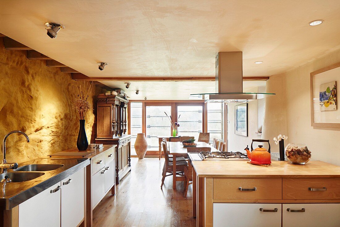 Dining area and illuminated rock wall in open-plan kitchen