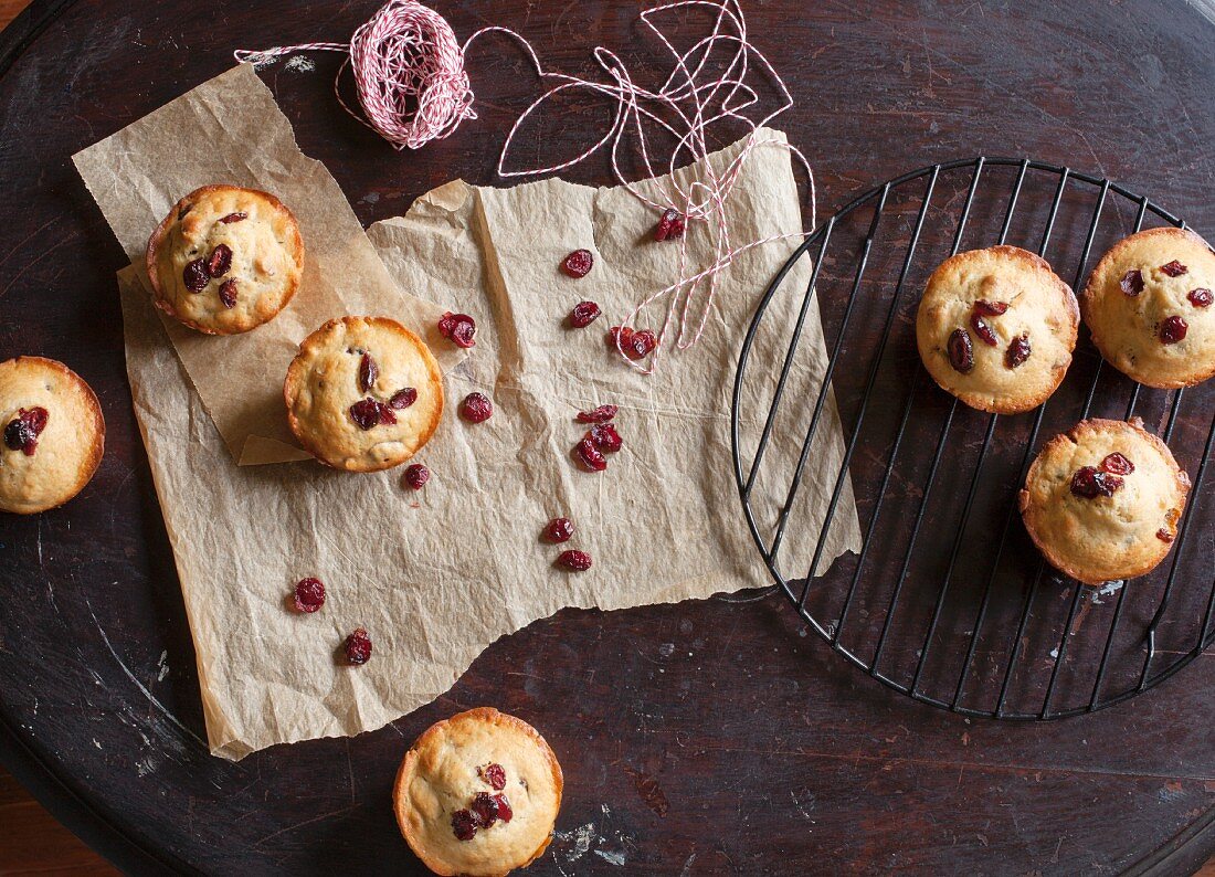 Freshly baked cranberry muffins cooling on rack and parchment paper