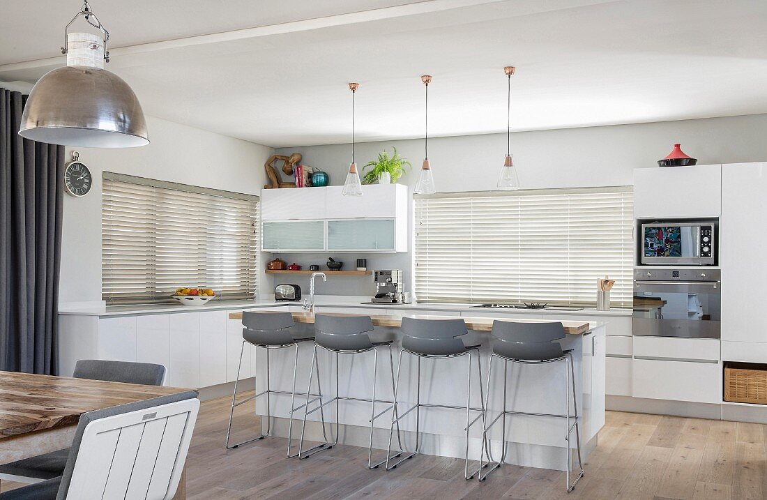 Bar stools at island counter in grey and white modern kitchen